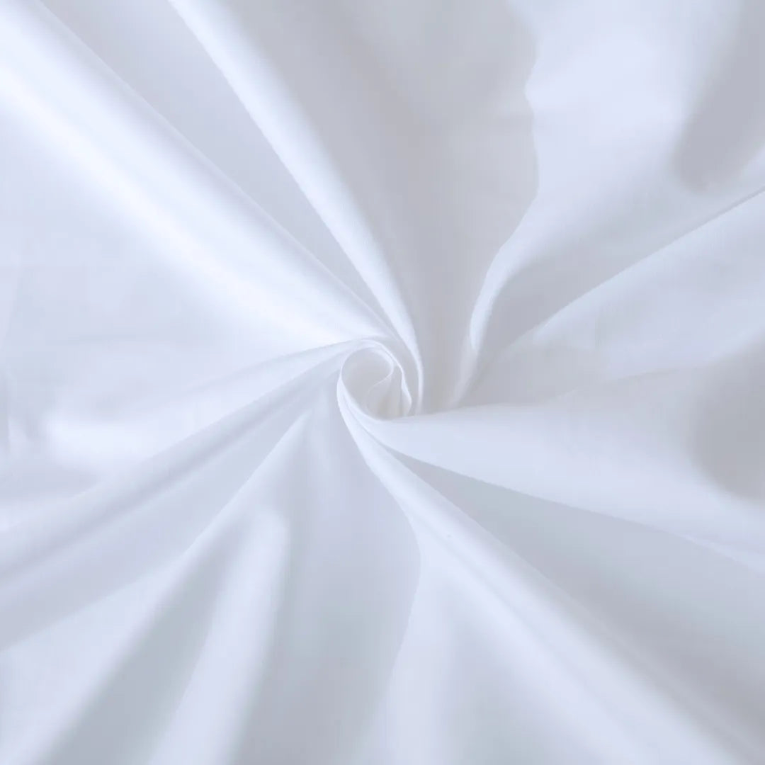 A swirl of smooth, white Linenly Luxe Sateen Flat Sheet creating a soft spiral texture.