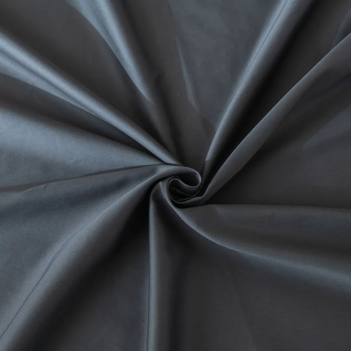 Elegant Linenly Sateen Pillowcase Set in Charcoal fabric twisted into a spiral design, showcasing its smooth texture and luxurious drape.
