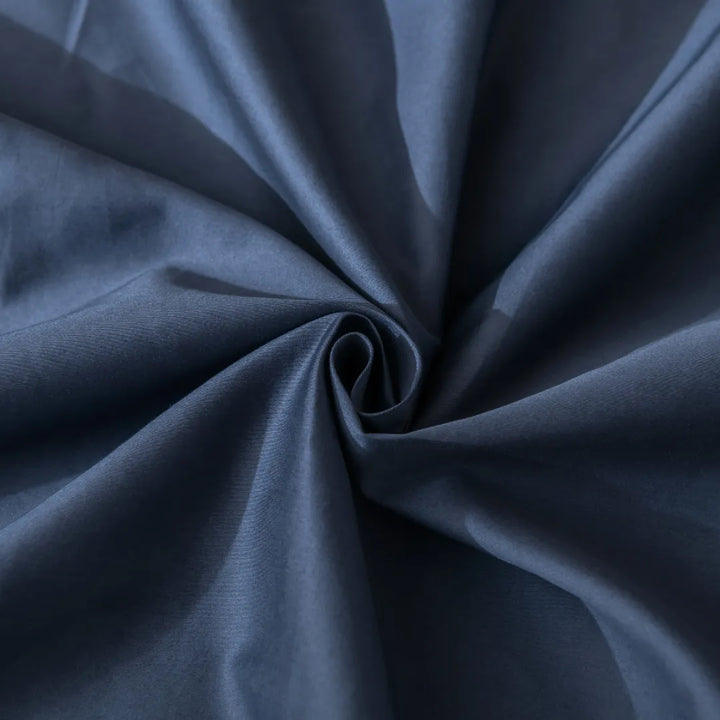 A close-up view of a swirl in a navy blue fabric with a smooth, luxurious texture ideal for Linenly's Luxe Sateen Pillowcase Set - Midnight featuring an envelope closure design.
