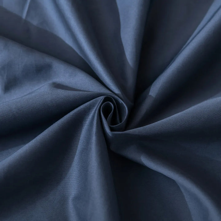Swirling navy blue fabric texture showcasing Linenly's Luxe Sateen Quilt Cover - Midnight, an elegant and smooth sateen weave textile.