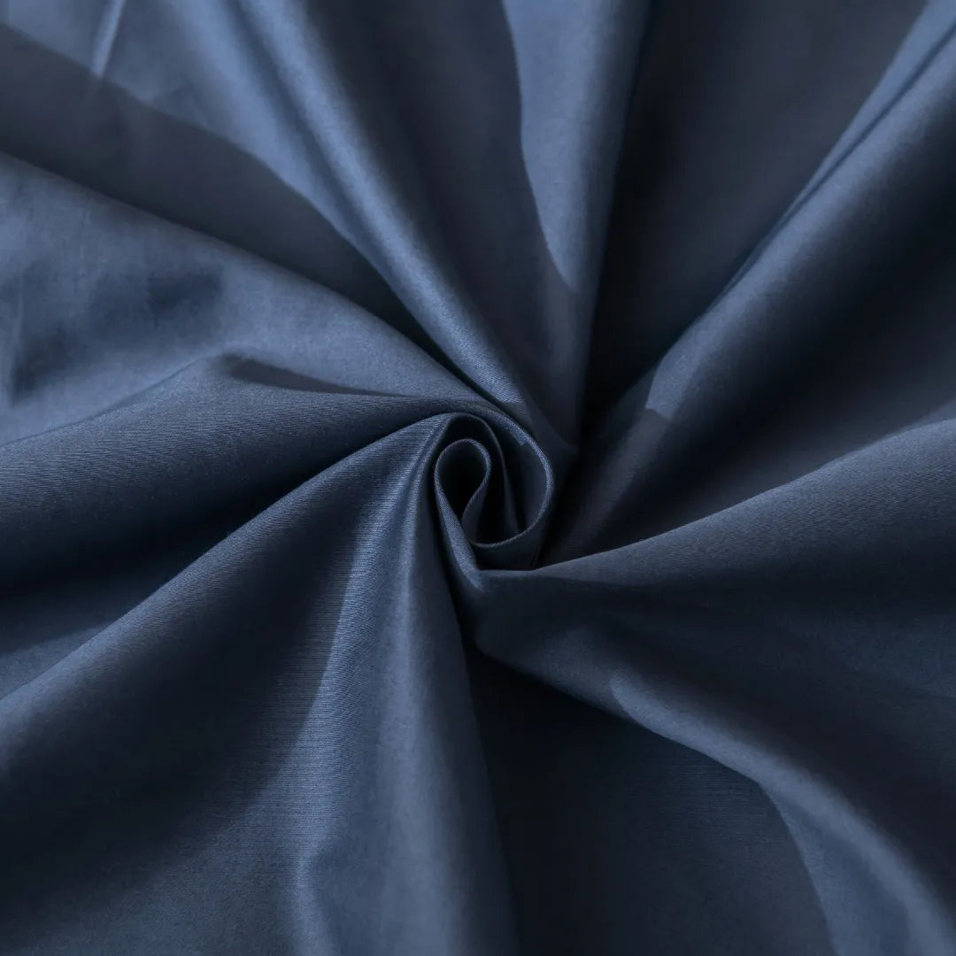 A close-up image of a swirled midnight Luxe Sateen Sheet Set by Linenly, showcasing its texture and draping quality.