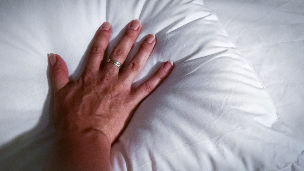 a hand touching Linenly bamboo pillowcase