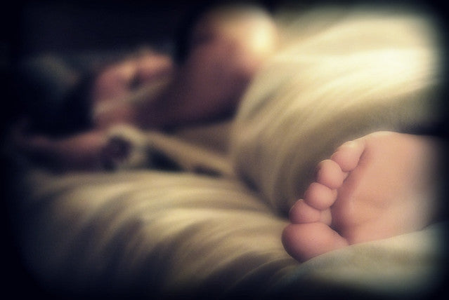 a person sleeping in bed and a foot can be seen