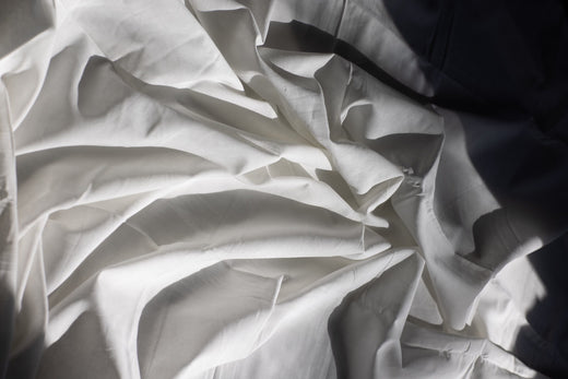 unfolded white bed sheets