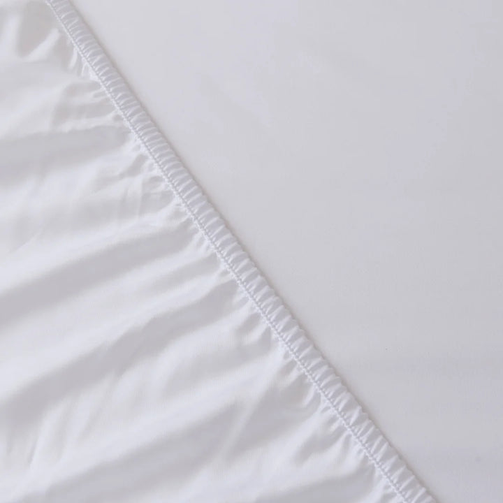 Close-up of a Linenly Bamboo Fitted Sheet - White with deep sides, crisp white fabric featuring a detailed view of its smooth texture and clean, finished edge.