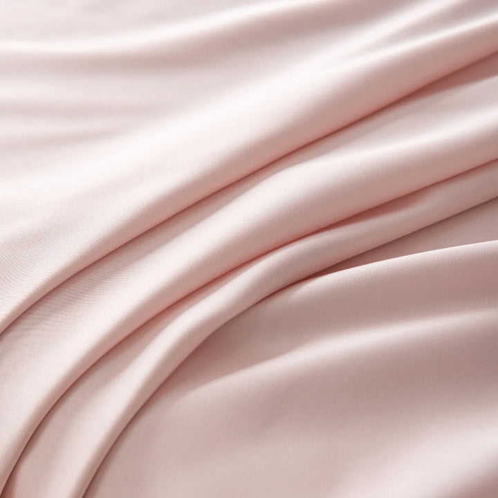 Elegant Linenly blush satin weave fabric gracefully folded with a smooth texture, conveying a sense of softness and luxury.