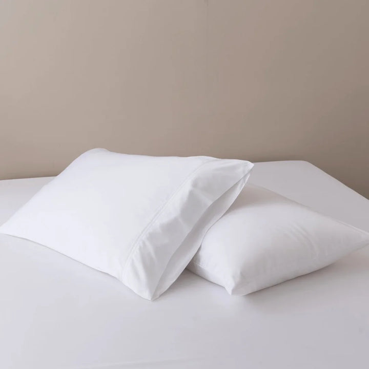 Two plush white pillows encased in Linenly Bamboo Pillowcase Sets on a clean, light-colored bedsheet, offering a sense of comfort and tranquility for restful sleep.