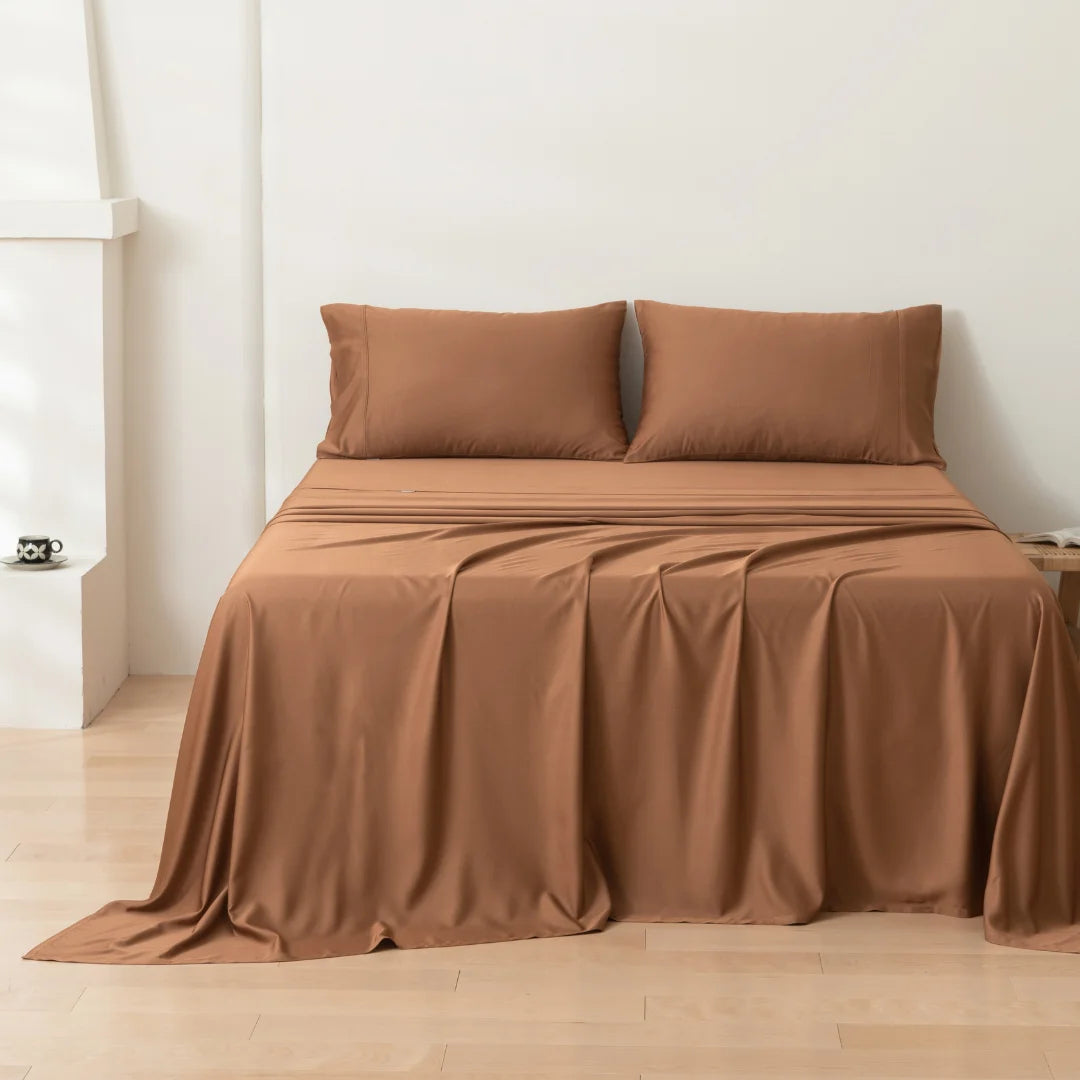 Elegant and neatly made bed with a Linenly terracotta bamboo sheet set in a minimalistic room.