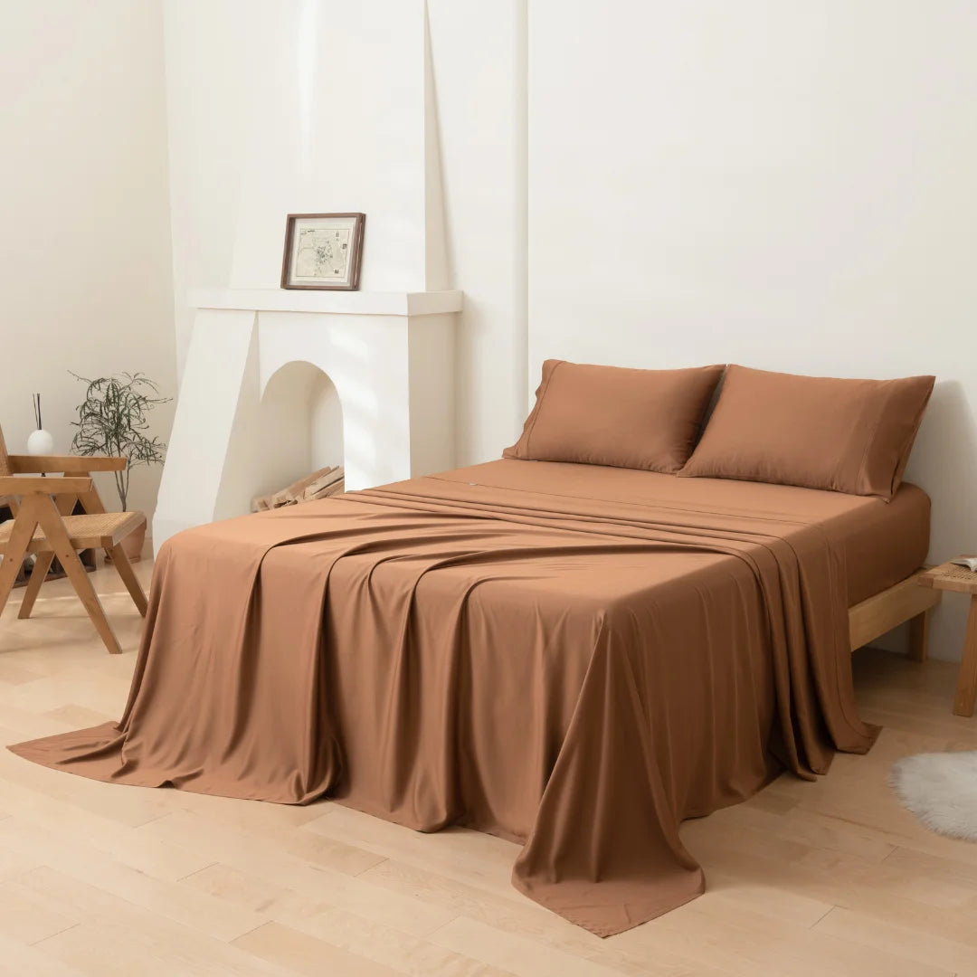 A neatly made single bed with a Linenly Terracotta Bamboo Sheet Set in a minimalist bedroom setting.