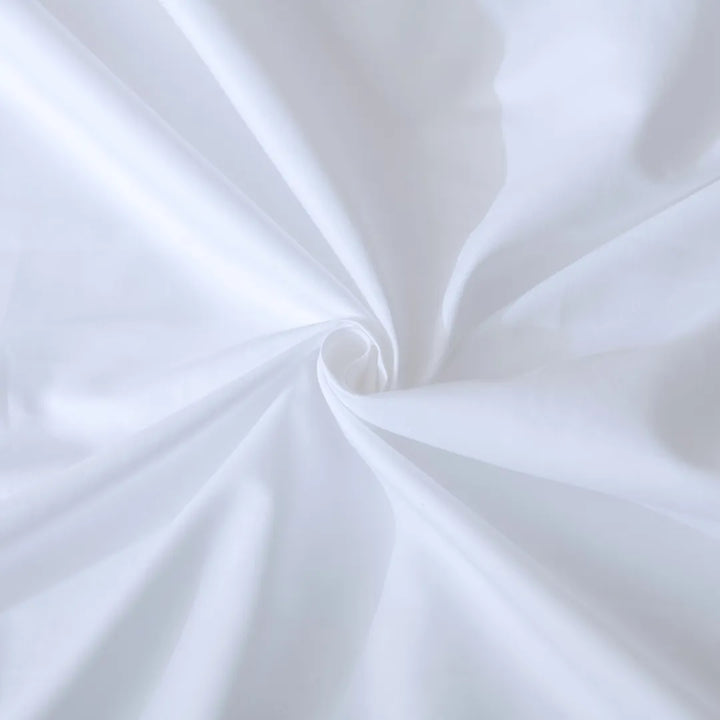 A swirl of smooth, white Linenly Luxe Sateen Flat Sheet creating a soft spiral texture.