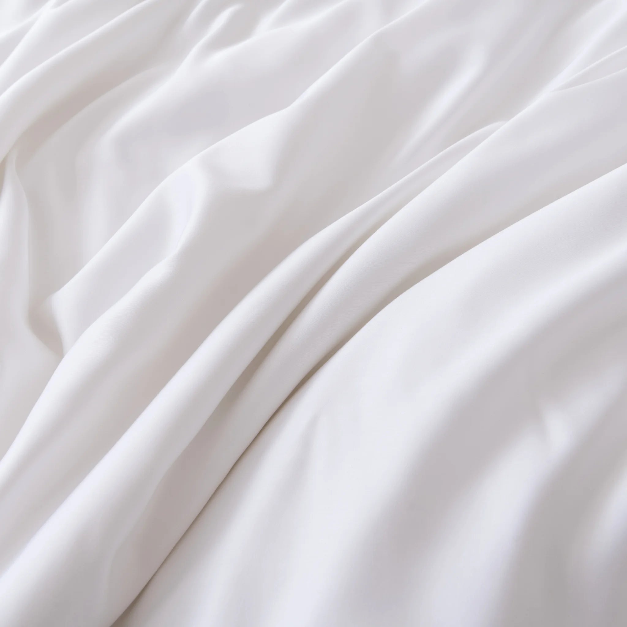 Experience the ultra-soft, smooth, and breathable Linenly Bamboo Sheet Set - White, featuring gentle folds that offer a calming sense of comfort for restful sleep.